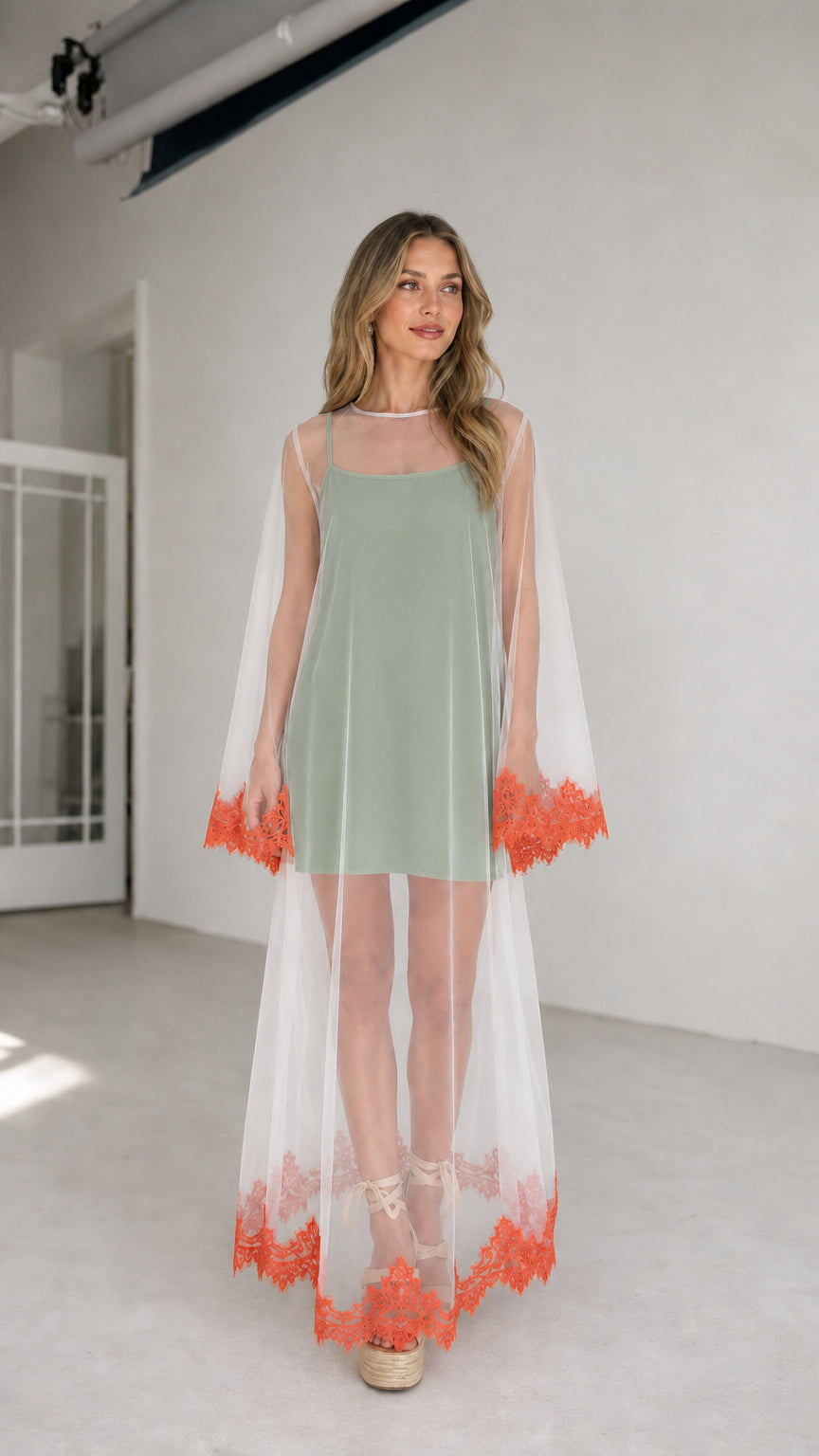 Model wearing sage inner dress with white embroidered mesh duster