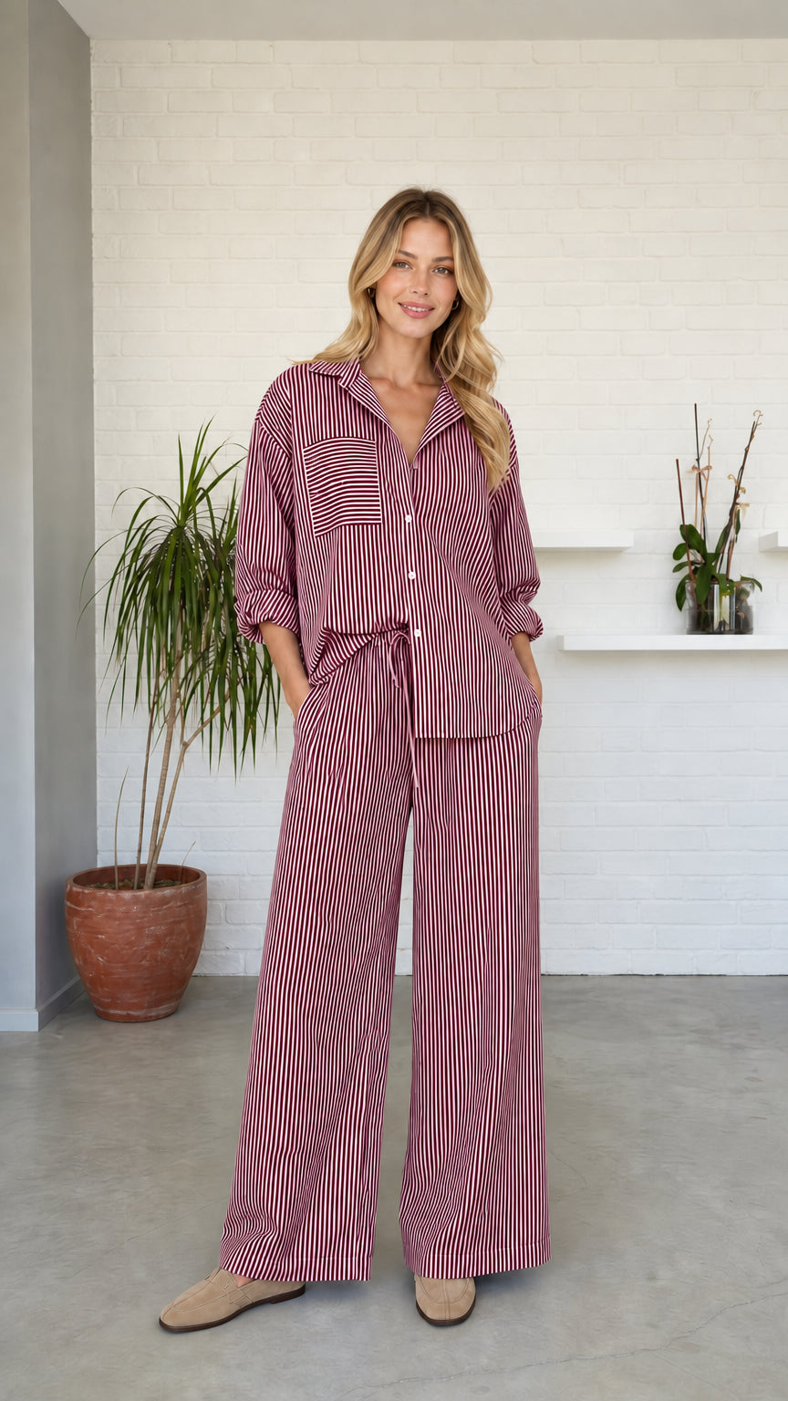 Woman wearing burgundy striped button-down shirt and wide-leg pants