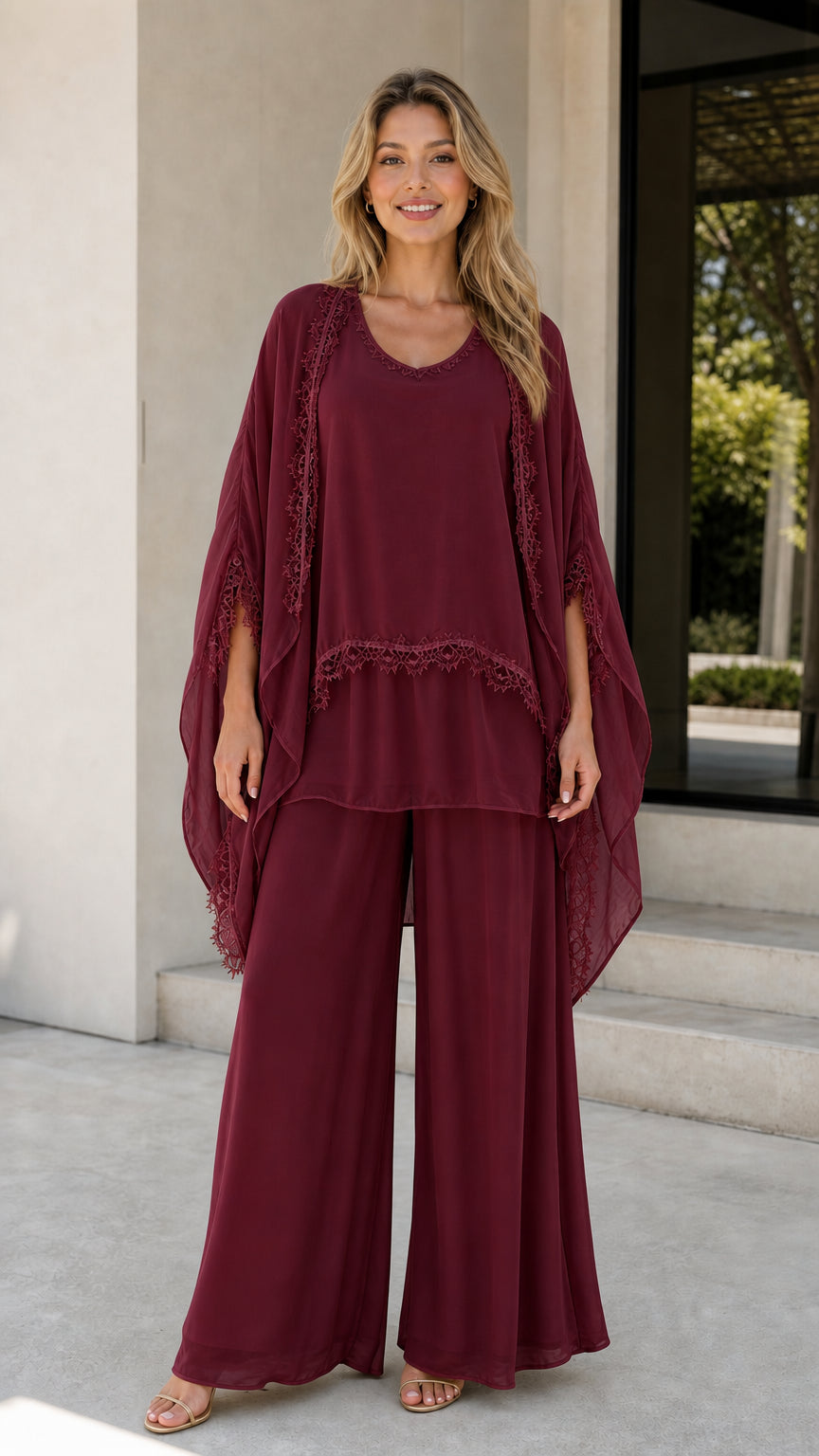 Model wearing burgundy chiffon 3-piece pants set with cape