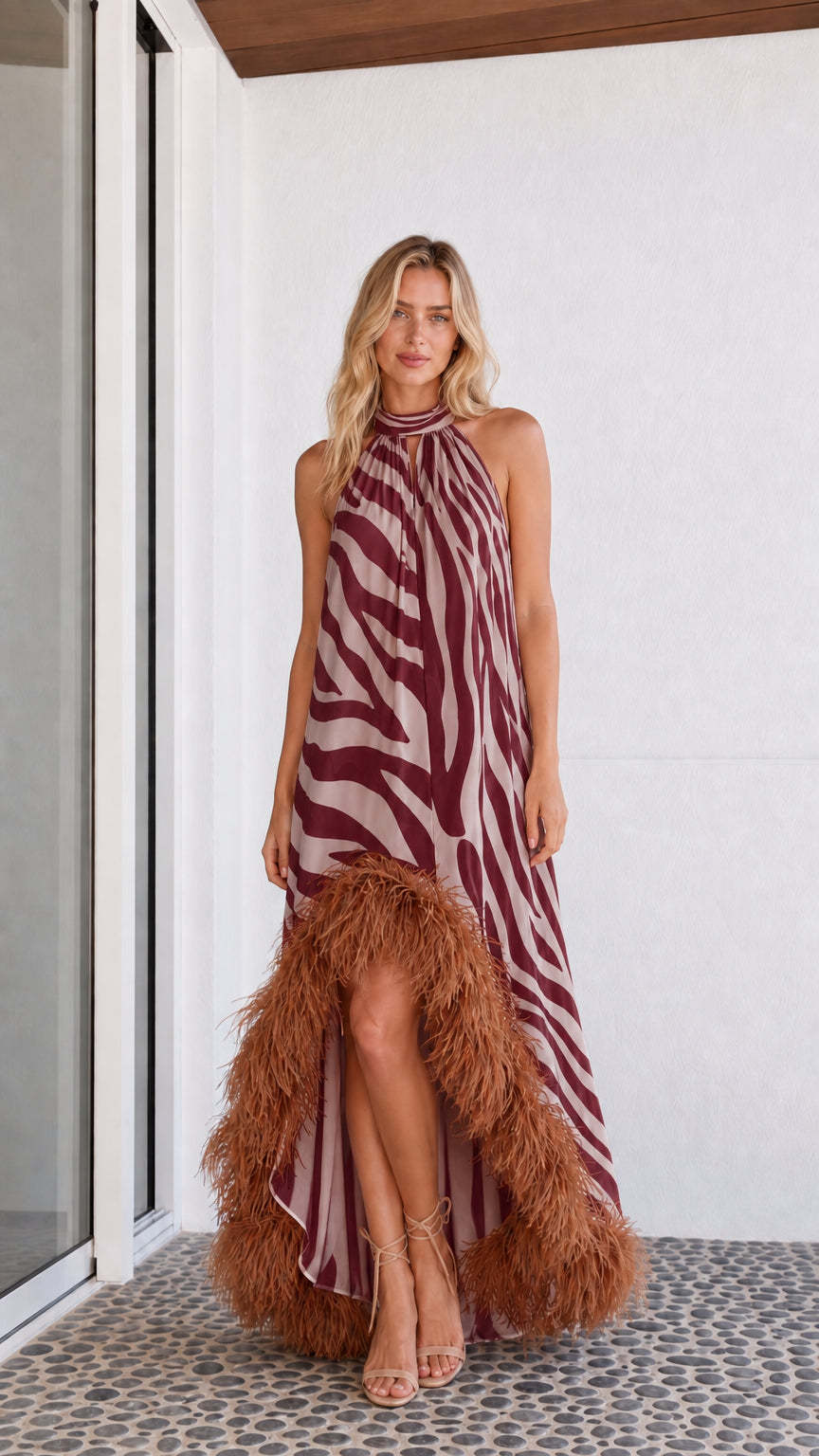 Model wearing burgundy zebra print maxi dress with feather hem