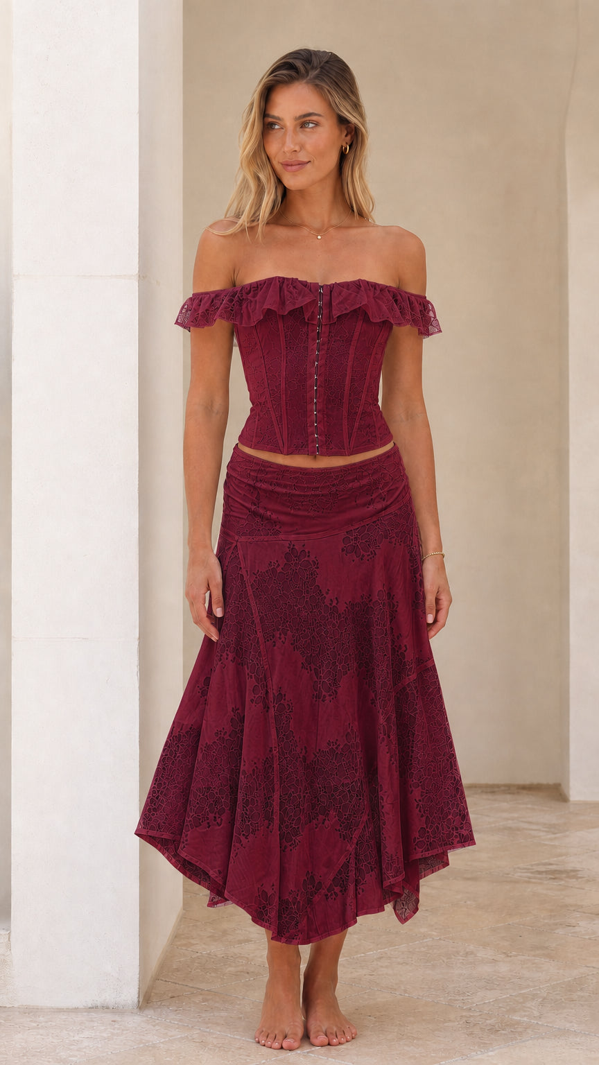 Woman wearing burgundy off-shoulder lace corset top and midi skirt set