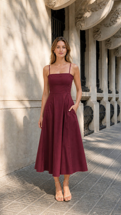 Full view of woman wearing burgundy midi dress with pockets