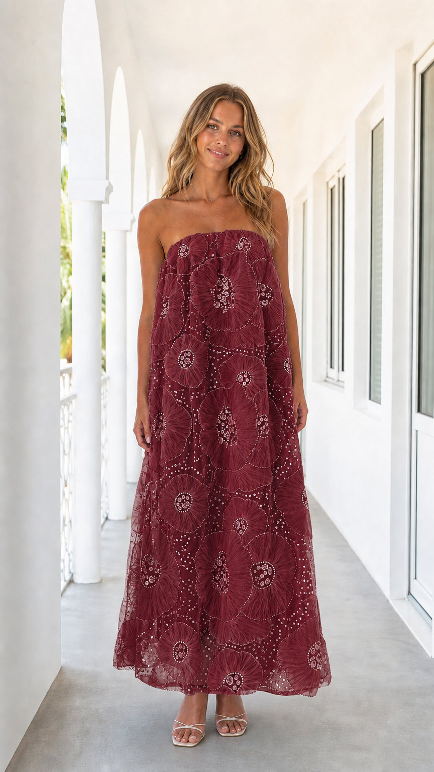 Woman wearing burgundy strapless floral mesh maxi dress