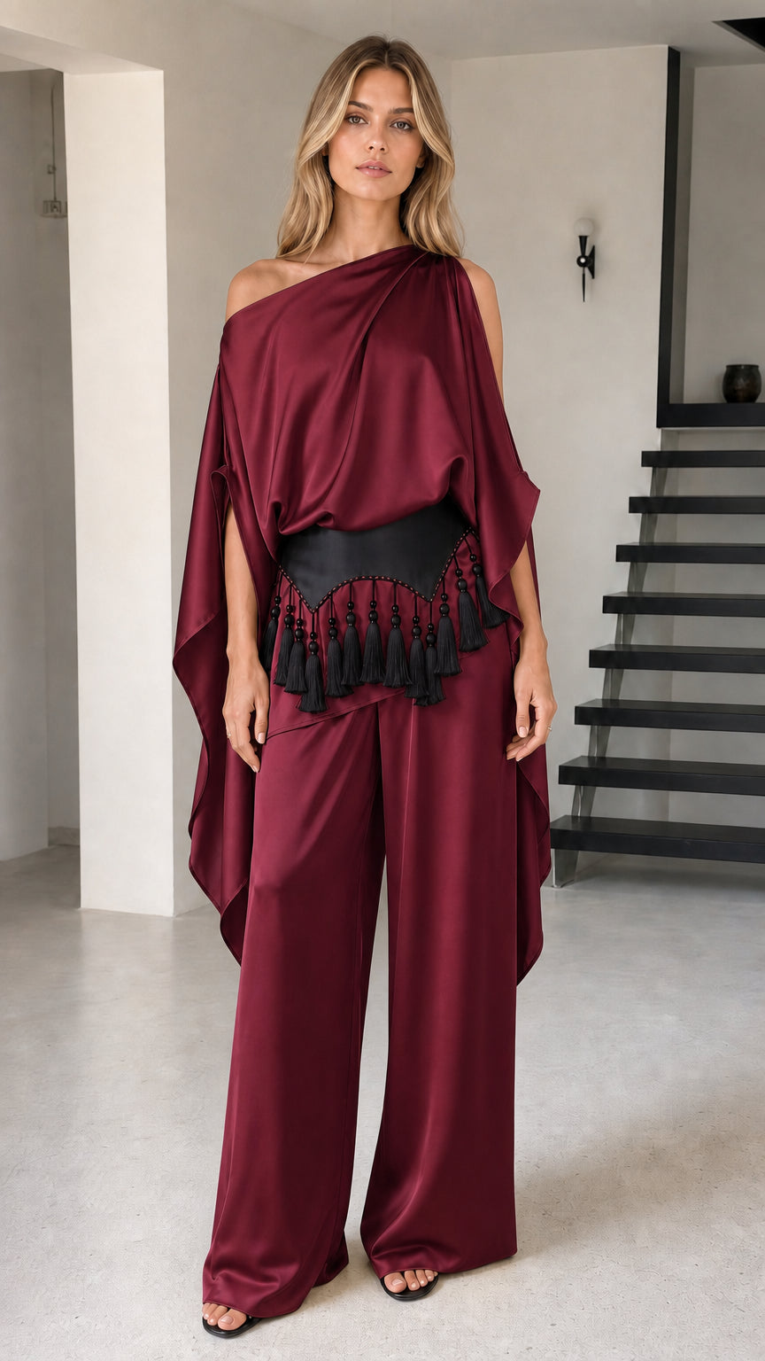 Model wearing burgundy wine draped cape top and wide-leg pants set