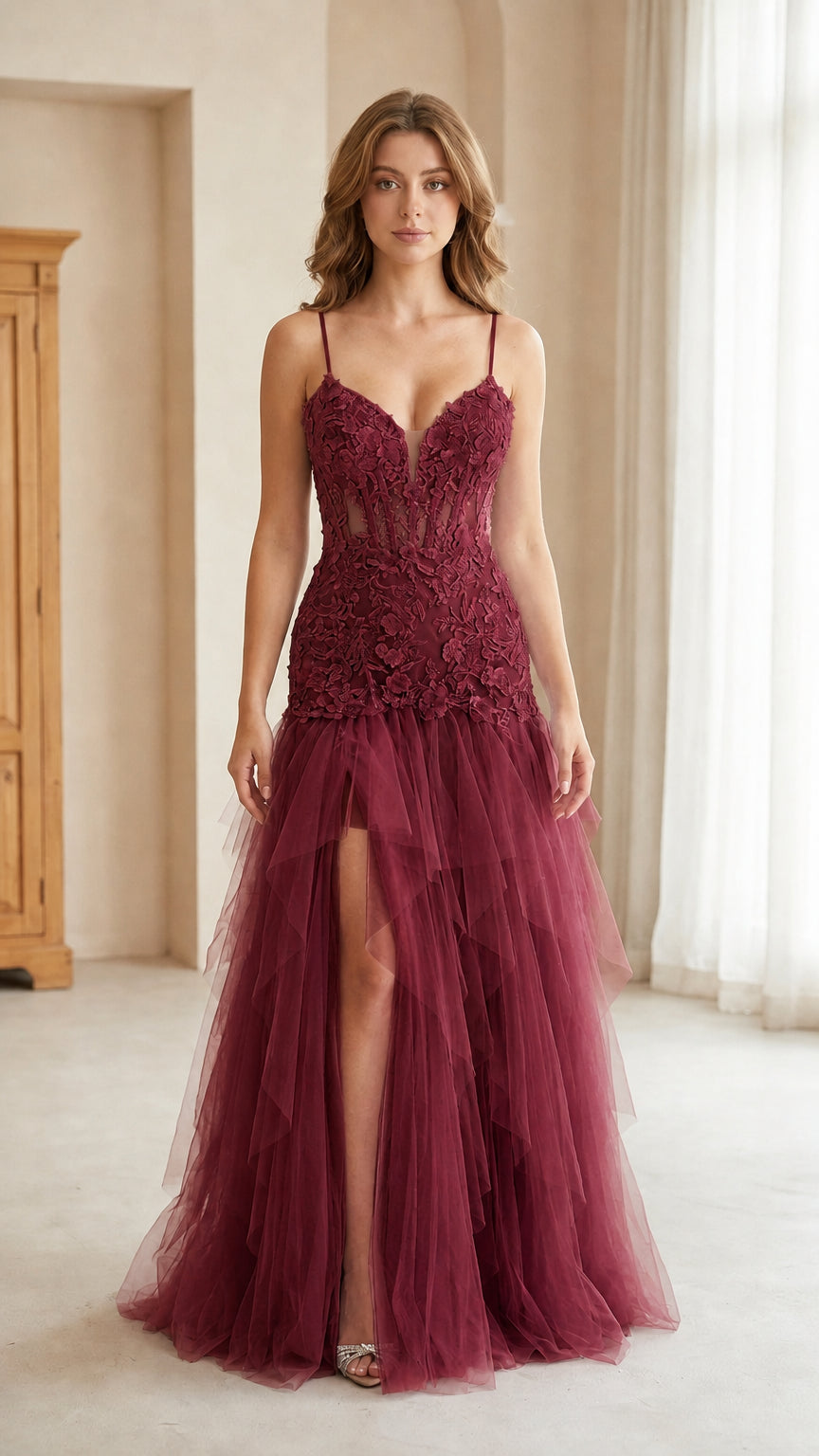 Front view of model wearing burgundy wine corset tulle gown with thigh slit