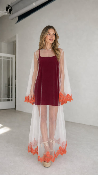 Model wearing burgundy inner dress with white embroidered mesh duster
