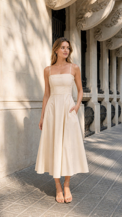 Full view of woman wearing beige midi dress with pockets