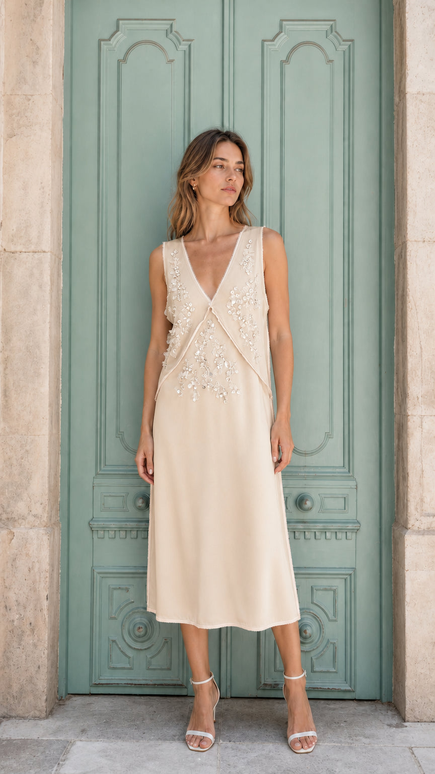 Model wearing champagne embellished sleeveless midi dress, front view