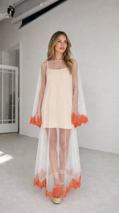 Model wearing champagne inner dress with white embroidered mesh duster