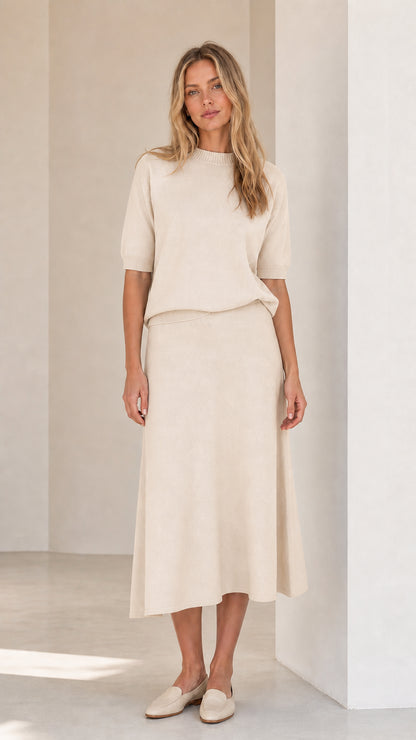 Woman wearing cream knit top and matching midi skirt set