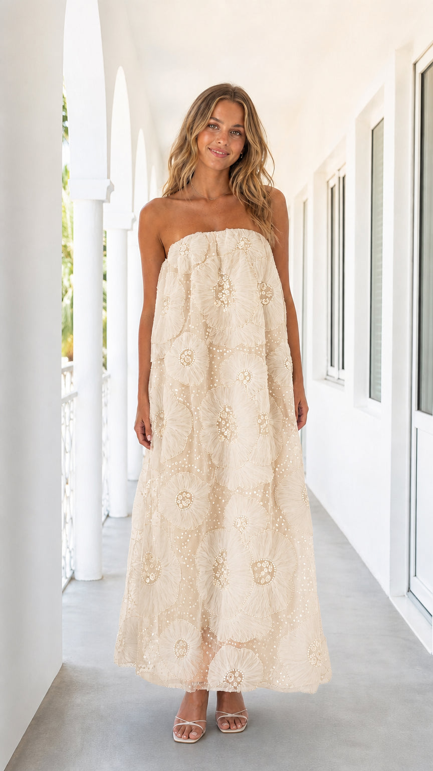 Woman wearing champagne strapless floral mesh maxi dress