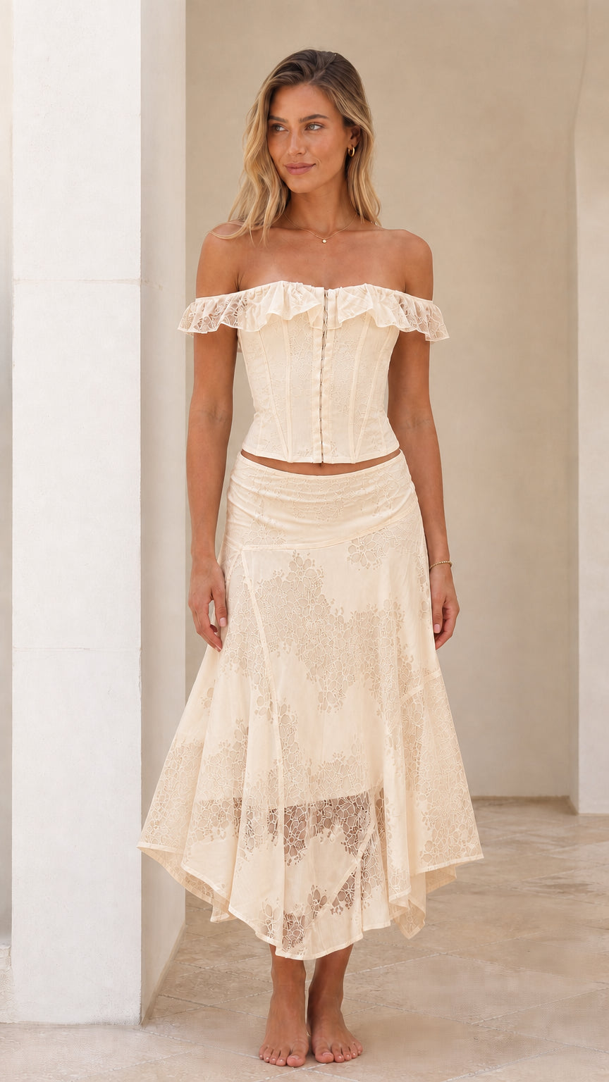 Woman wearing cream off-shoulder lace corset top and midi skirt set